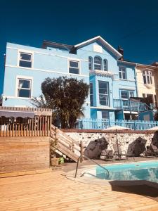 uma casa azul com uma piscina em frente em The Purple Tree Guest House em Torquay