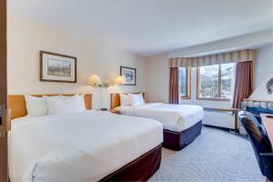 um quarto de hotel com duas camas e uma janela em Chateau Canmore em Canmore