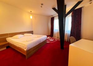 a bedroom with a large bed with a cross on it at Hotel Ave Lux in Braşov