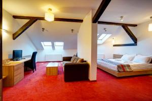 1 dormitorio con 1 cama, escritorio y TV en Hotel Ave Lux, en Brasov