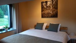 a bedroom with a bed with a deer painting on the wall at Le Clos du Cerf - Silence & nature in Stoumont