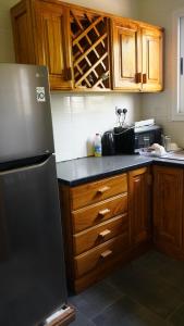 a kitchen with a black refrigerator and wooden cabinets at Maajob Resort in Brikama