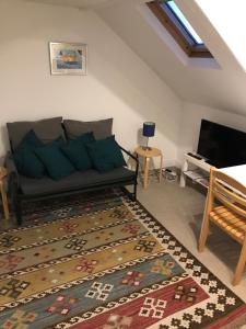 ein Wohnzimmer mit einem Sofa und einem TV in der Unterkunft Cosy Loft Apartment in Georgian Home in Plymouth