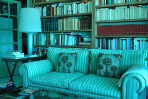 niebieska kanapa w bibliotece z książkami w obiekcie Les pieds dans l'eau w mieście Blonville-sur-Mer