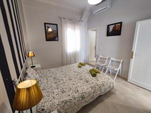 ein Schlafzimmer mit einem Bett und zwei Stühlen darin in der Unterkunft Manuel Agustín Heredia in Málaga