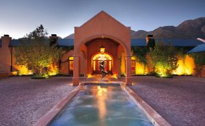 a house with a fountain in front of a building at La Residence in Franschhoek