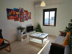 ein Wohnzimmer mit einem Couchtisch und einem TV in der Unterkunft Manuel Agustín Heredia in Málaga
