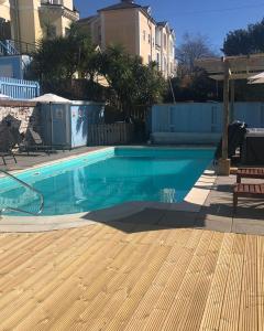 a swimming pool with blue water in a yard at The Purple Tree Guest House in Torquay
