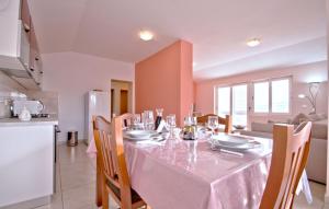Apartment Frlan في فيلا لوكا: غرفة طعام مع طاولة ومطبخ