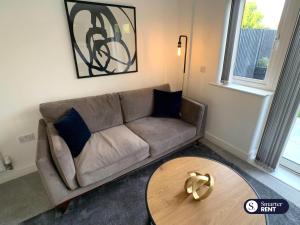 uma sala de estar com um sofá e uma mesa em High Wycombe - 2 Bedroom House em Buckinghamshire