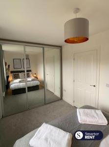 um quarto com um espelho e uma cama em High Wycombe - 2 Bedroom House em Buckinghamshire