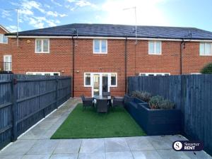 a garden with a table and chairs in front of a house at High Wycombe - 2 Bedroom House in Buckinghamshire
