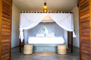 a bedroom with a canopy bed with a window at Villa Binn by Kabana in Prea