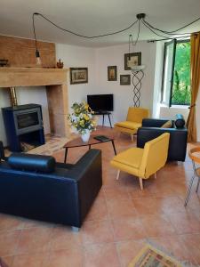 ein Wohnzimmer mit zwei Sofas und einem Kamin in der Unterkunft GITE AU ROC DE BOURZAC AVEC PISCINE PRIVÉE in Bayac