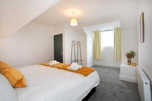 a bedroom with a large white bed and a window at Cudworth House, Barnsley for families, Biz & contractors etc in Barnsley