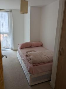 a bedroom with a bed in a room with a window at 2 Bed 2 baths Apt in Stratford in London