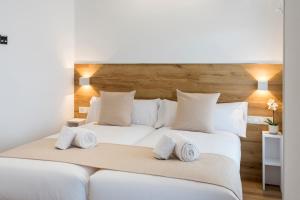 a bedroom with two beds with white sheets and pillows at Elegant Rooms Lasarte in Lasarte