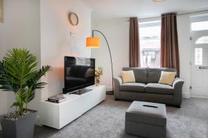 a living room with a tv and a couch at Cudworth House, Barnsley for families, Biz & contractors etc in Barnsley