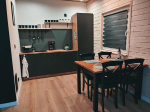 Leśny Reset في مارونجوفو: مطبخ مع طاولة وكراسي في غرفة