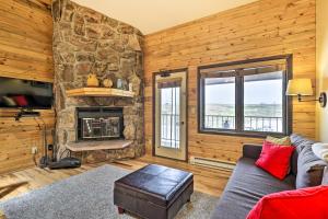 sala de estar con chimenea de piedra y sofá en Cozy Granby Mountain Condo with Resort Amenities!, en Granby
