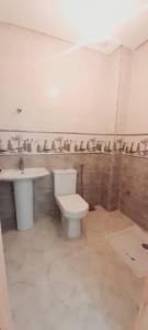 a bathroom with a toilet and a sink at Appartement de luxe à el jadida in El Jadida