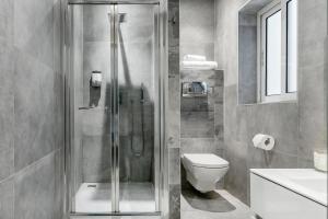 uma casa de banho com um chuveiro, um WC e um lavatório. em Award Winning Apartment St Julians em St. Julian's