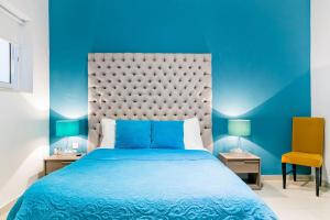 - une chambre bleue avec un lit et deux lampes dans l'établissement Award Winning Apartment St Julians, à San Ġiljan