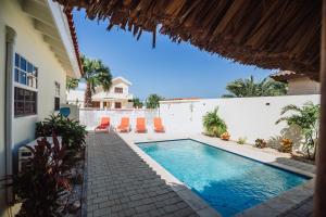 a swimming pool in a yard with a house at Dushi Villa in Palm-Eagle Beach