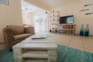 a living room with a coffee table and a tv at Dushi Villa in Palm-Eagle Beach