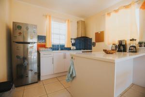 鷹海灘的住宿－Dushi Villa，厨房配有白色橱柜和冰箱。
