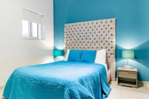 - une chambre bleue avec un lit et un mur bleu dans l'établissement Award Winning Apartment St Julians, à San Ġiljan