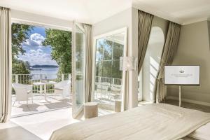 バート・ザーローにあるVilla Contessa - Luxury Spa Hotelsのベッドルーム1室(ベッド1台付)、景色を望むバルコニーが備わります。