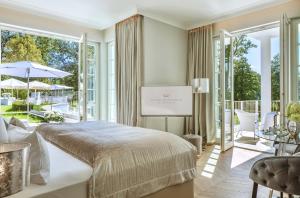 a bedroom with a bed and a large window at Villa Contessa - Luxury Spa Hotels in Bad Saarow