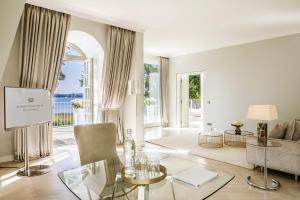 ein Wohnzimmer mit einem Glastisch und einem Sofa in der Unterkunft Villa Contessa - Luxury Spa Hotels in Bad Saarow