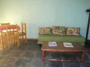 ein Wohnzimmer mit einer grünen Couch und einem Tisch in der Unterkunft Ubatuba Surf Spot in Ubatuba