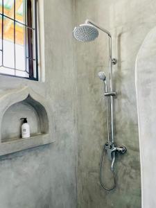 a shower with a shower head in a bathroom at Blue Reef Sport & Fishing Lodge and Bungalows in Jambiani