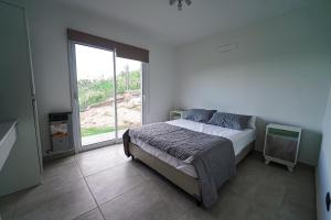 a bedroom with a bed and a large window at Sunset Village in Villa Carlos Paz +65 photos