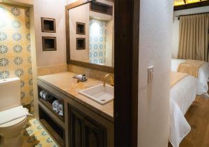 a bathroom with a sink and a toilet and a bed at Hotel Casa Alcestre in Villa de Leyva
