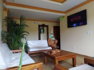 a living room with two beds and a table at Hostal El Eden de Mindo in Mindo