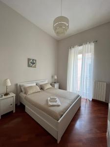a white bedroom with a large bed and a window at La terrazza di nonno Ciccio in Monopoli