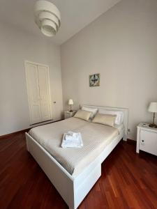 a bedroom with a white bed and two night stands at La terrazza di nonno Ciccio in Monopoli