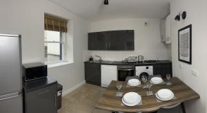 a kitchen with a table with white plates on it at 1 The Croft in Cockermouth