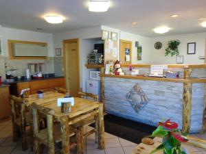 a restaurant with two tables and a counter and a kitchen at Western Motel in Gunnison