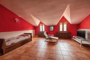 Habitación roja con 2 camas y TV. en Casa rural collao de lobo, en Serradilla