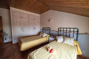 1 Schlafzimmer mit 2 Betten und einem Teddybär auf dem Bett in der Unterkunft Casa rural collao de lobo in Serradilla