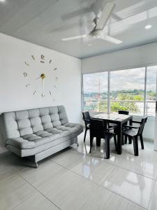 sala de estar con sofá, mesa y reloj en TORRES DEL MESÓN LUXURY APARTMENTS Doradal, en Doradal