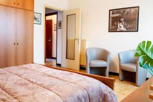 una camera con due sedie e un letto di IN VILLA Relax a 200 metri da mare e centro a Loano