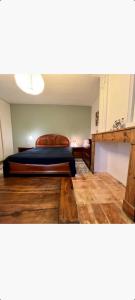 ein Schlafzimmer mit einem Bett und einem Holzboden in der Unterkunft GITE AU ROC DE BOURZAC AVEC PISCINE PRIVÉE in Bayac