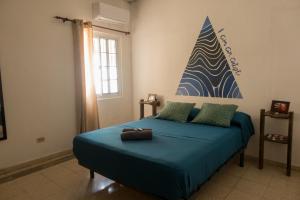 una camera da letto con un letto con lenzuola blu e un cartello sul muro di The Corner Hostel a Playa Blanca
