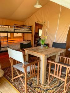 a wooden table and chairs in a tent at Tienda de Safari Almagro in Montecorto